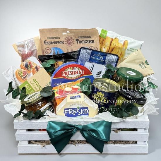 Набор закусок к столу в деревянном ящике: мясная нарезка, сыры, оливки, антипасти